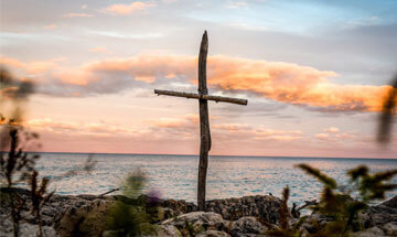 cross with lake as backdrop